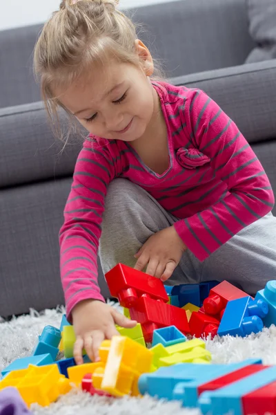 Kleines Mädchen spielt mit Blöcken — Stockfoto