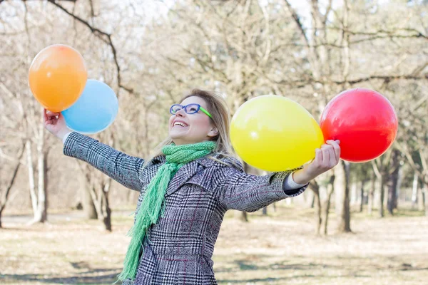 Mujer joven feliz con globos de colores — Foto de Stock