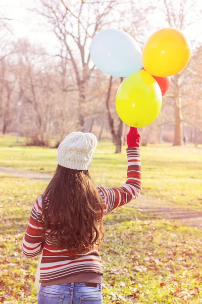 Kobieta trzyma kolorowe balony odkryty — Zdjęcie stockowe