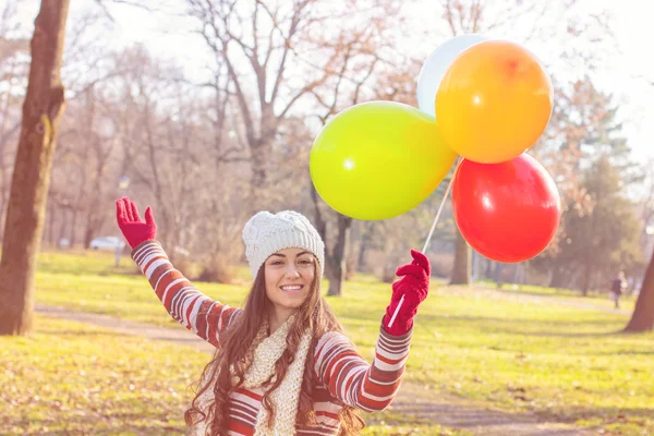 Gelukkig jonge vrouw met kleurrijke ballonnen — Stockfoto