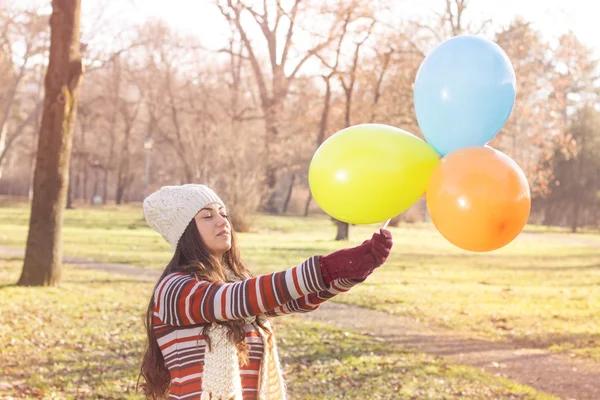 Glückliche junge Frau mit bunten Luftballons — Stockfoto