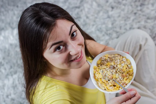 Счастливая молодая женщина ест зерновой завтрак — стоковое фото