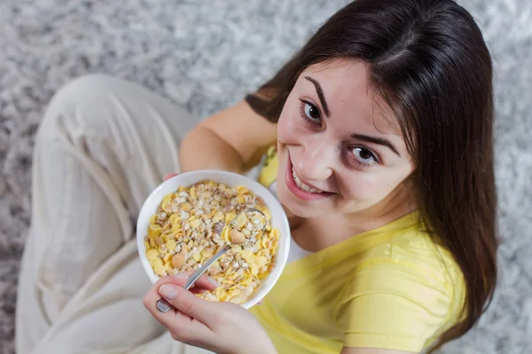 Glad ung kvinna äter flingor frukost — Stockfoto