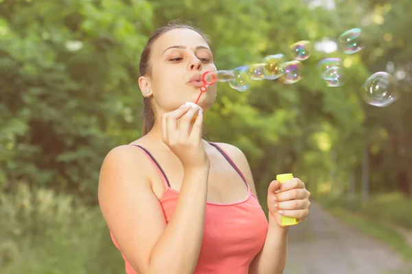 Jeune femme soufflant des bulles — Photo