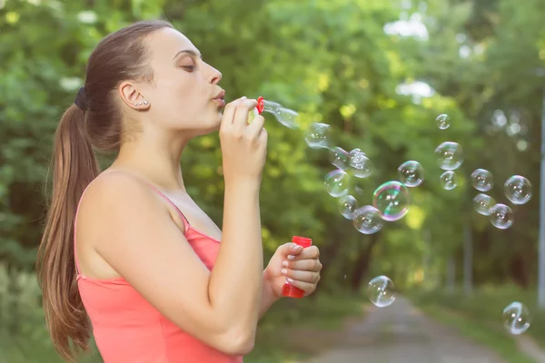 Giovane donna soffia bolle — Foto Stock