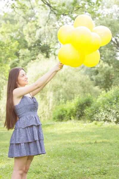 Szczęśliwa młoda kobieta z żółtym balony — Zdjęcie stockowe