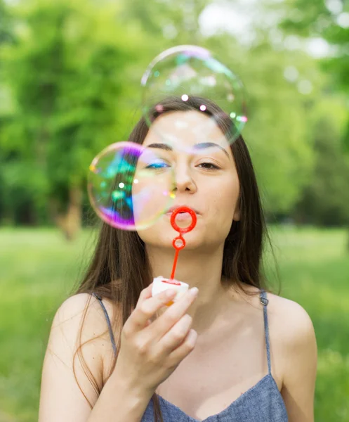 Jovem mulher soprando bolhas — Fotografia de Stock