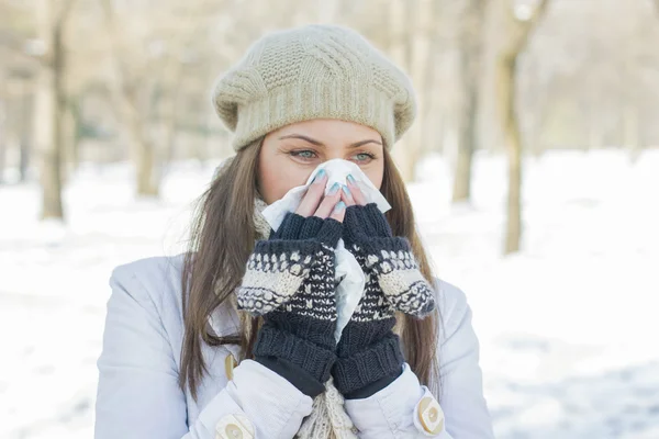 Fiatal nő a téli ruházat, fúj az orra — Stock Fotó