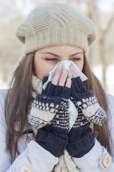 Wanita muda dengan baju musim dingin mengembus hidung — Stok Foto