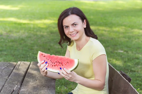 Улыбающаяся молодая женщина ест арбуз — стоковое фото