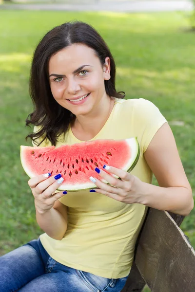 微笑着的年轻女人吃西瓜 — 图库照片