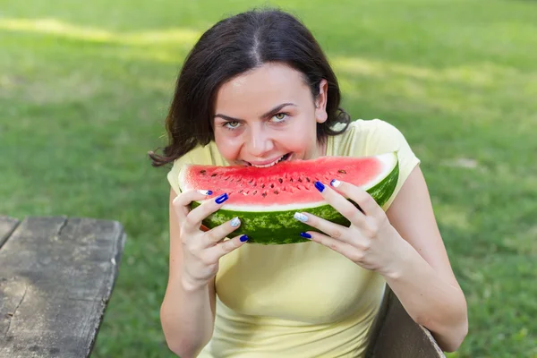 Sorridente giovane donna mangiare anguria — Foto Stock