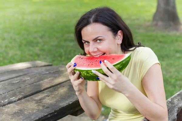 Sorridente giovane donna mangiare anguria — Foto Stock