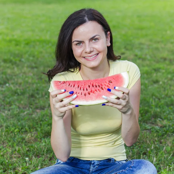 Sorridente giovane donna mangiare anguria — Foto Stock