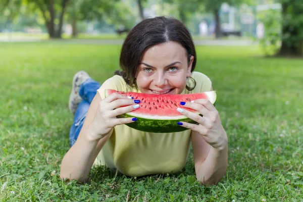 Sorridente giovane donna mangiare anguria — Foto Stock