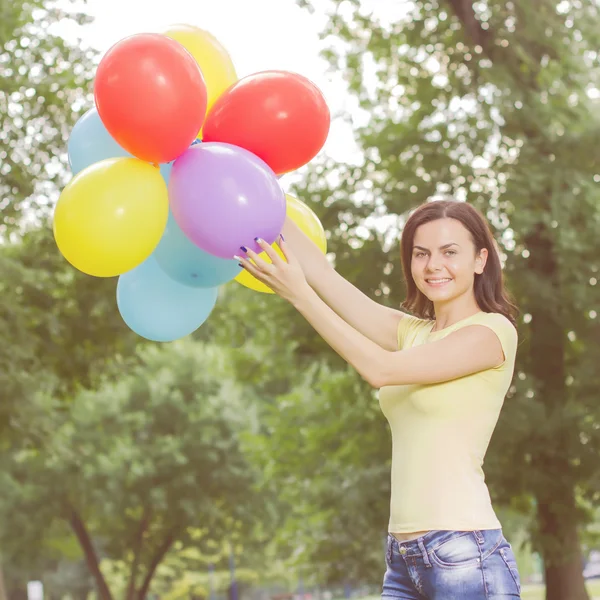 Joyeux jeune femme avec des ballons colorés — Photo