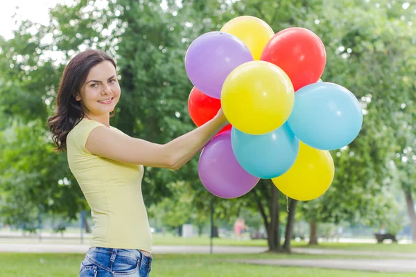 Gelukkig jonge vrouw met kleurrijke ballonnen — Stockfoto