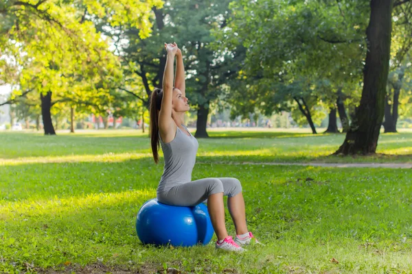 Ejercicio saludable de la mujer joven de la aptitud con la bola de Pilates al aire libre — Foto de Stock