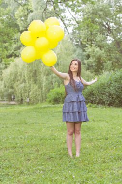Mutlu genç kadın sarı balonları