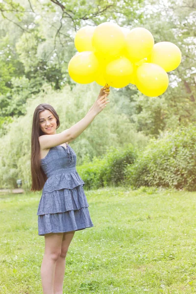 Felice giovane donna con palloncini gialli — Foto Stock