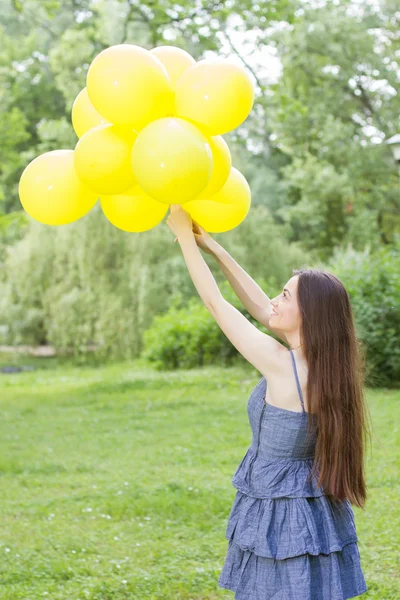Boldog, fiatal nő, a sárga lufi — Stock Fotó