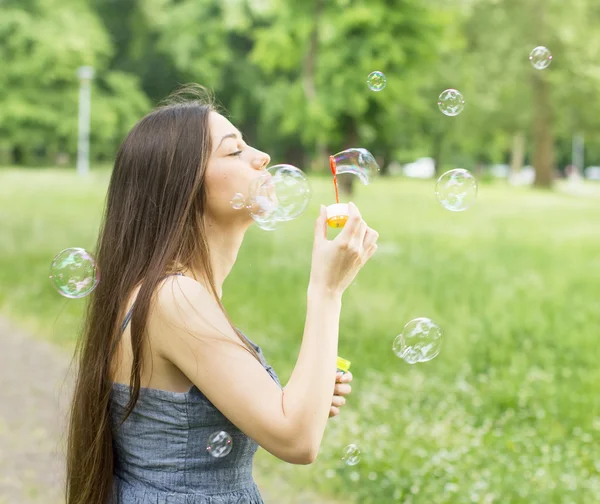 Jonge vrouw blazen bubbels — Stockfoto