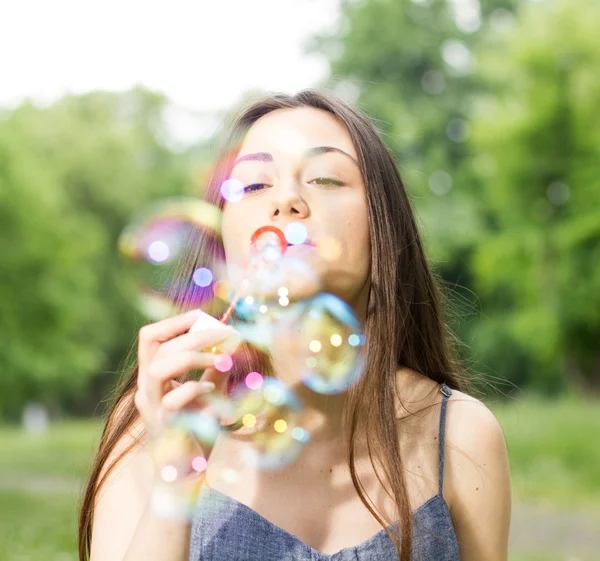 Jonge vrouw blazen bubbels — Stockfoto