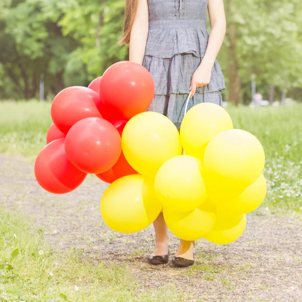 Beztroski, wolności kobieta z czerwonymi i żółtymi balonami — Zdjęcie stockowe