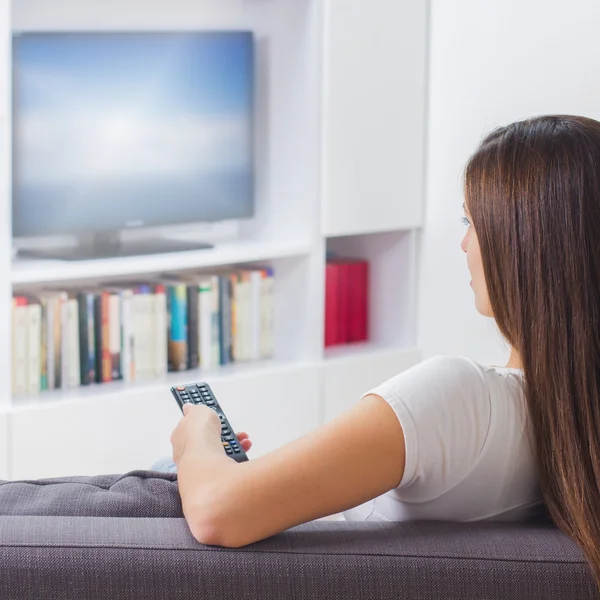 Egy nő otthon tévézik. — Stock Fotó