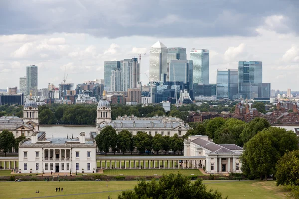 Londen-augustus 12: queens huis met de skyline van canary wharf — Stockfoto