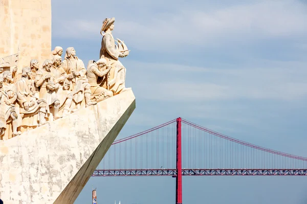 Памятник открытиям и 25 апреля мост в Лиссабоне, Пор — стоковое фото