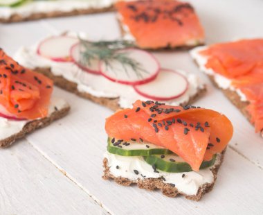 Somon ve sebzeli kanepeler ve sandviçler ahşap arka planda