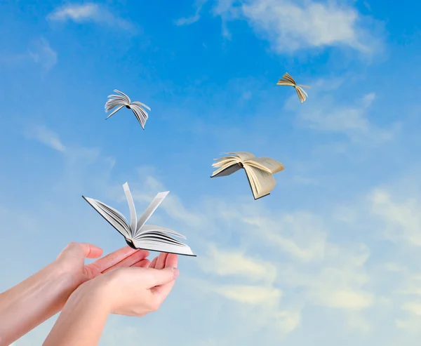 Books flying from hands — Stock Photo, Image