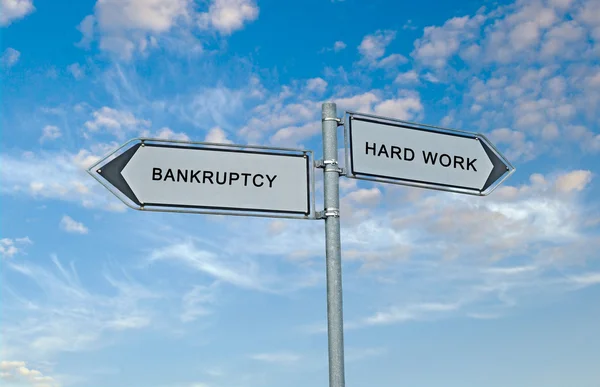 Dopravní značka k bankrotu a tvrdé práce — Stock fotografie