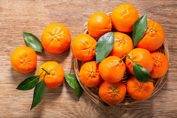 Fresh mandarin oranges fruit or tangerines on a wooden table, top view