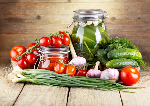 Preserved tomatoes and cucumbers with fresh vegetables — Stock Image Preserved tomatoes and cucumbers with fresh vegetables Stock Image