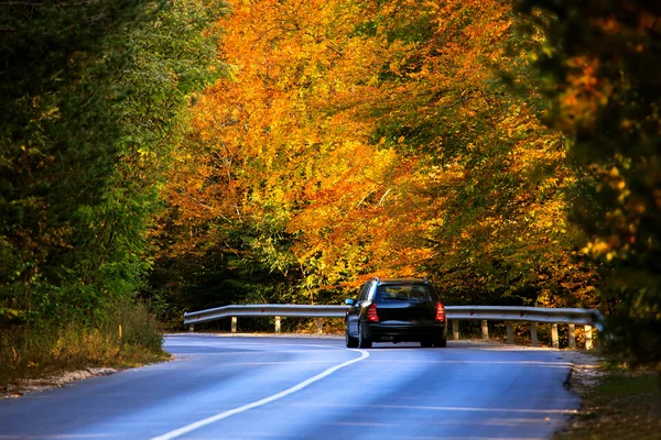 Carro na estrada de outono — Fotografia de Stock