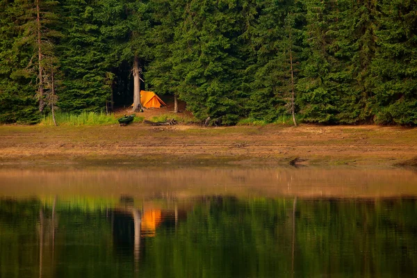 Oranje zonsondergang met tent op lake — Stockfoto