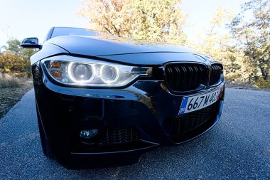 VELINGRAD, BULGARIA - NOVEMBER 4, 2025: Side view of BMW 3 Series F30 M Sport sedan parked along a mountain road during autumn.