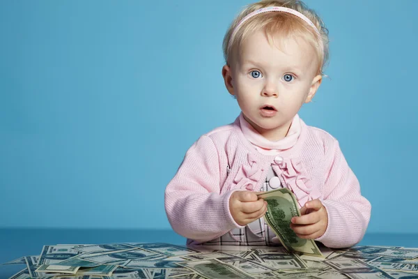 Little child with dollars on table — Stock Photo, Image