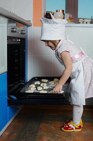 Маленький милий шеф-кухар готує в духовці — стокове фото