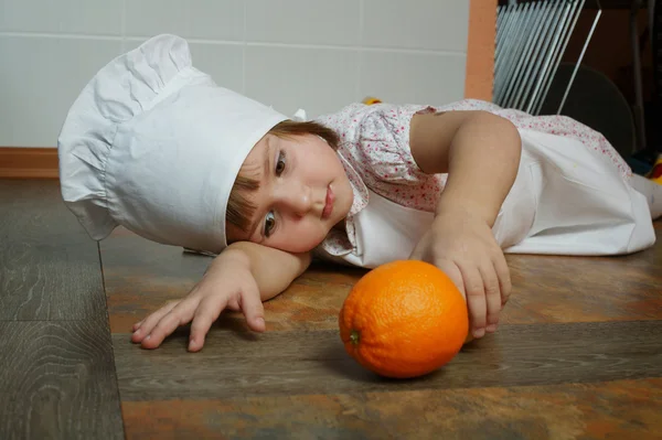 Pequeno chef bonito deitado no chão — Fotografia de Stock