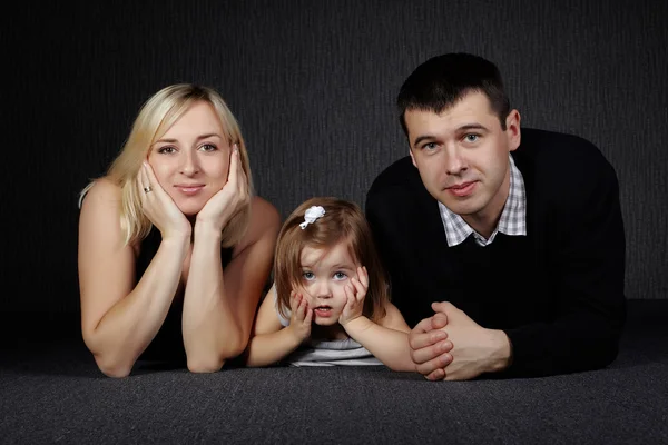 Lycklig familj på mörk bakgrund — Stockfoto