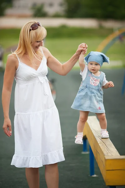 Mother with daughter on horizontal bar balance — Stock Photo, Image