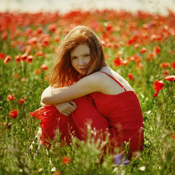 양 귀 비 필드에 빨간 머리의 아름 다운 소녀 — 스톡 사진