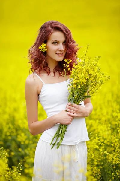Ung vacker flicka i gult fält — Stockfoto