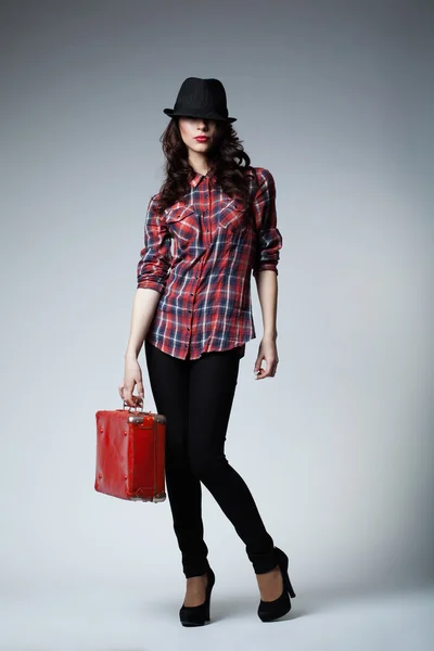 Beautiful brunette girl with red suitcase — Stock Photo, Image