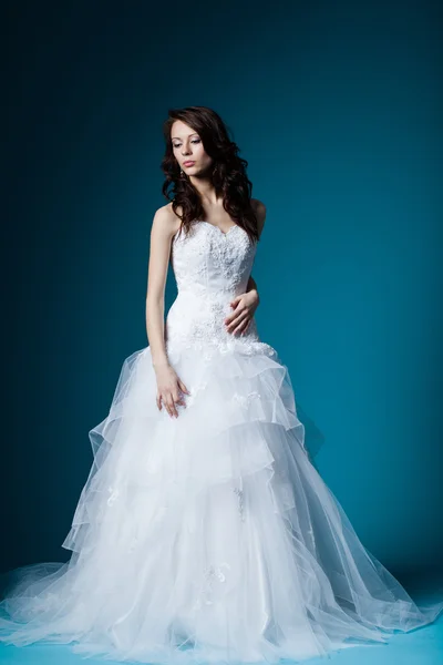 Krásná nevěsta ve svatebních šatech na modré — Stock fotografie