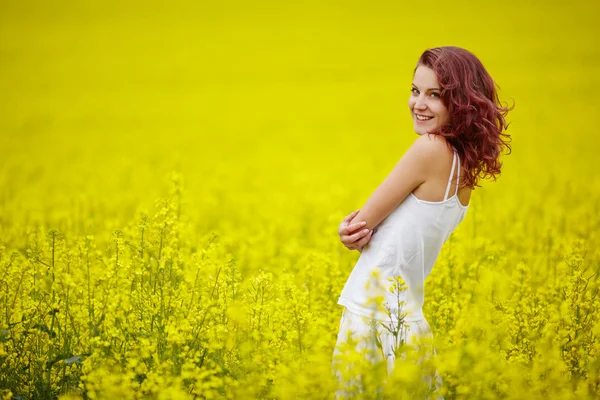 Ung vacker flicka i gult fält — Stockfoto