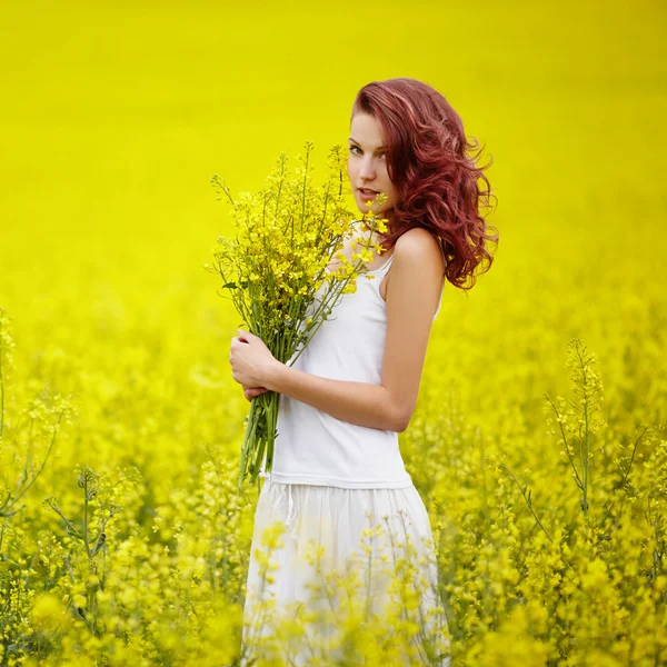 Ung vacker flicka i gult fält — Stockfoto